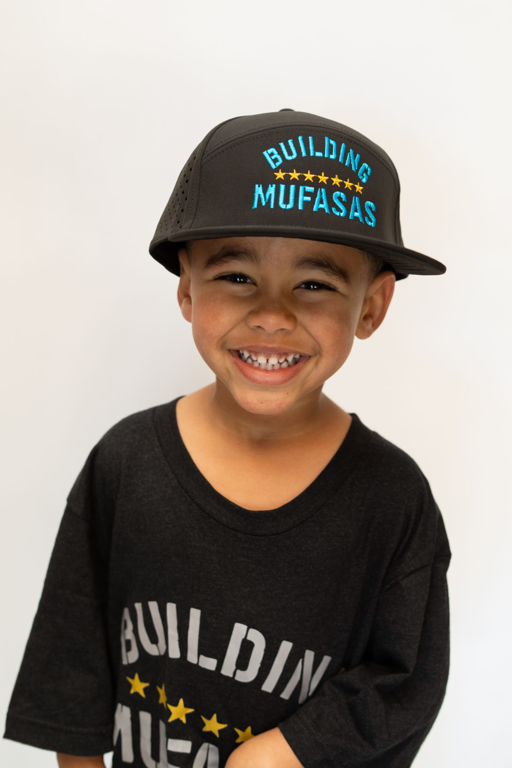 Black Building Mufasas hat with blue embroidered logo worn from front view