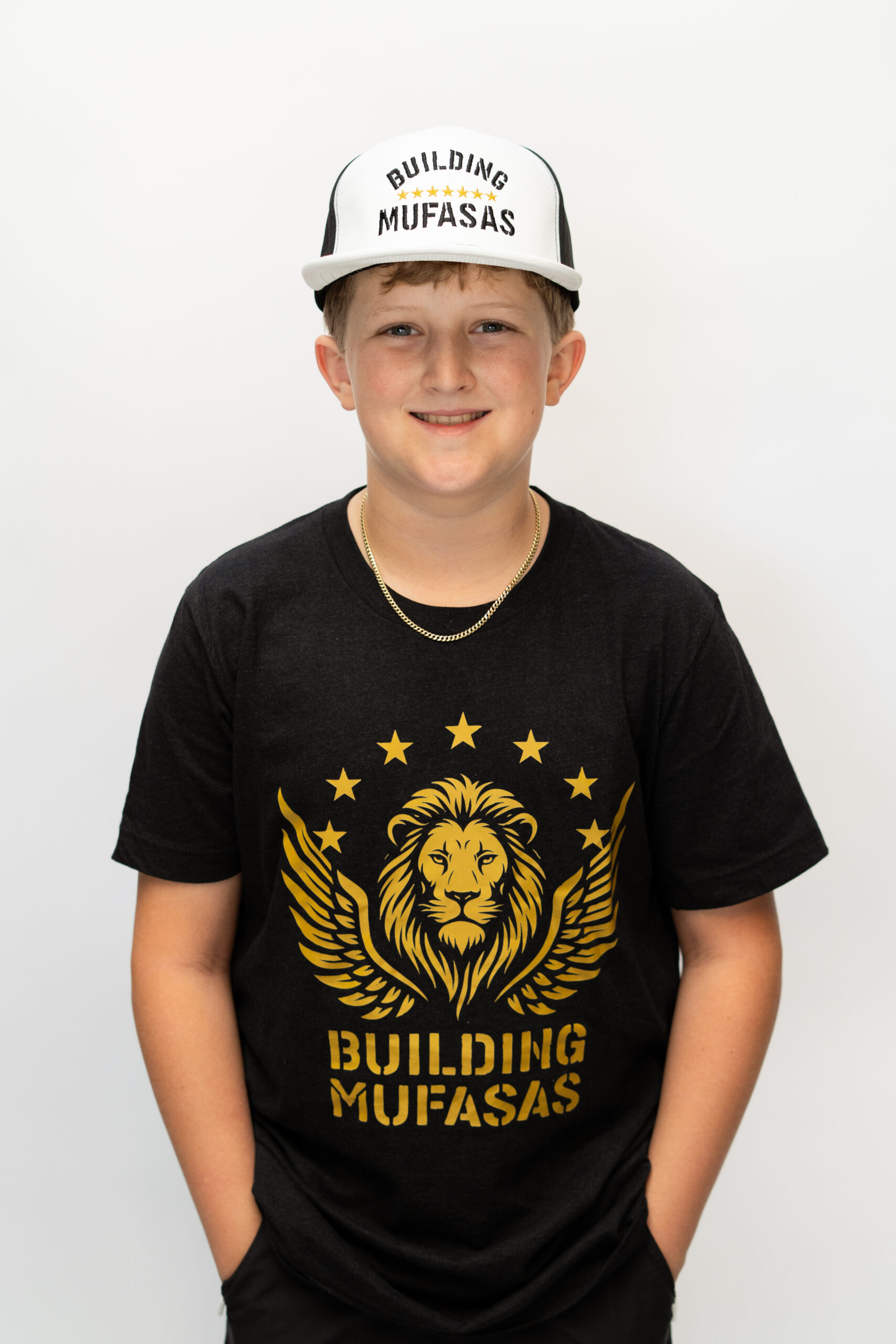 White and black Building Mufasas embroidered hat with gold star details worn from front view