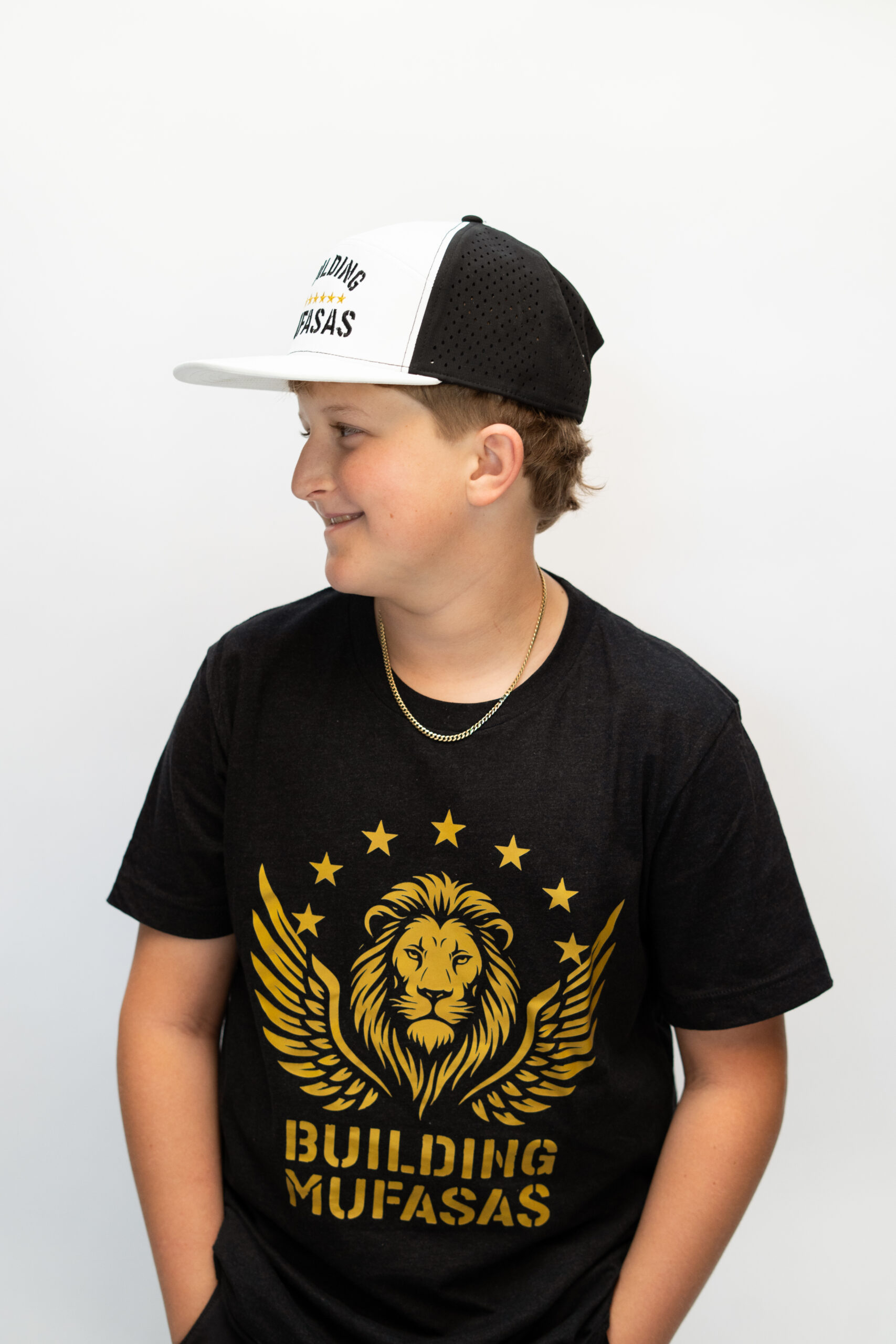 White and black Building Mufasas embroidered hat with gold star details worn from side view