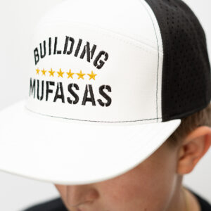 White and black Building Mufasas embroidered hat with gold star details worn from side angle